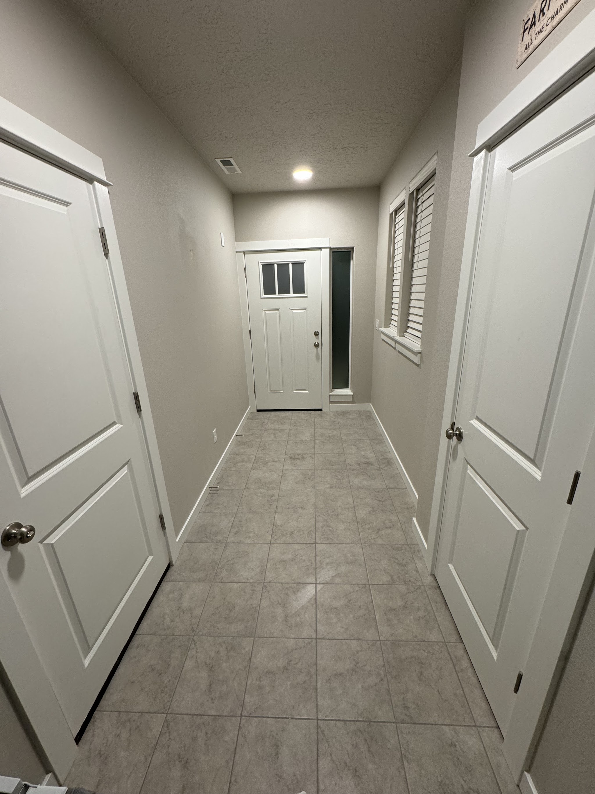 A finished entryway with tile flooring leading to the front door