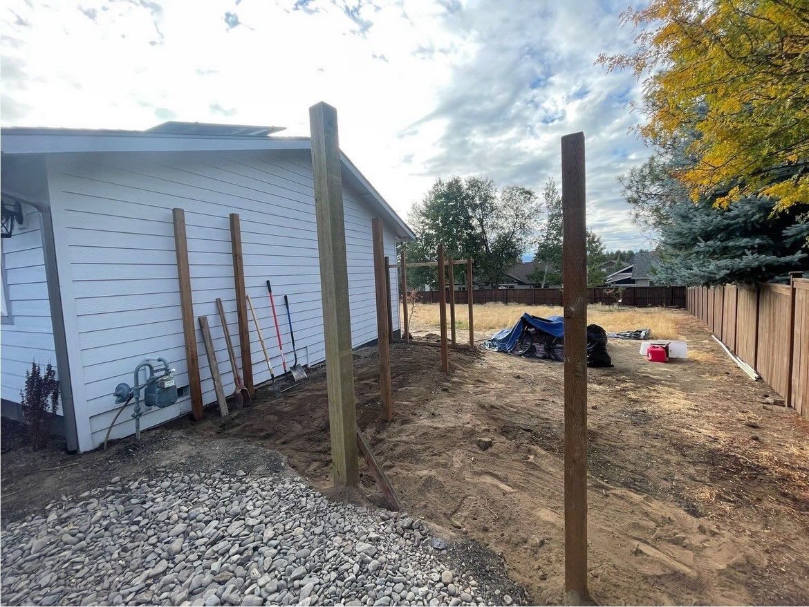 New fence posts being installed along the side of a home